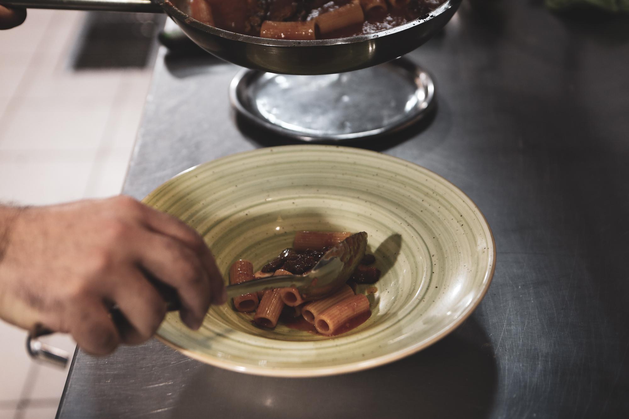 chef arranging plated dish on wooden table